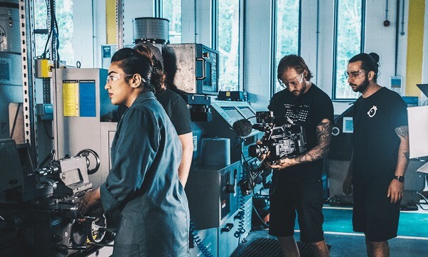 Three people standing and one people standing with camera